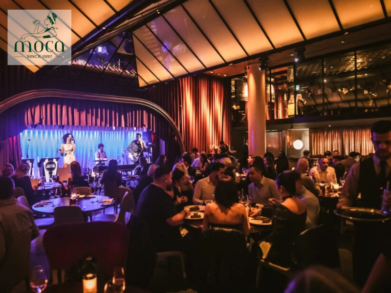 A fine dining setting with live string quartet, piano, or acoustic guitar, providing an elegant musical backdrop for intimate dining.