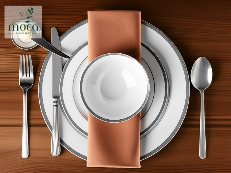 Im Mittelpunkt: Der Platzteller bildet den Anker des Gedecks, links davon der Brotteller mit Buttermesser, darauf die Suppenschale, und die Serviette elegant gefaltet.